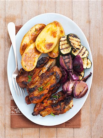 Grilled pork ribs with courgette, onion and baked potatoes Stockbilder - Premium RF Lizenzfrei, Bildnummer: 659-07739802