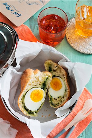 simsearch:659-08903489,k - A bread roll filled with egg and spinach in a bread basket Foto de stock - Royalty Free Premium, Número: 659-07739931