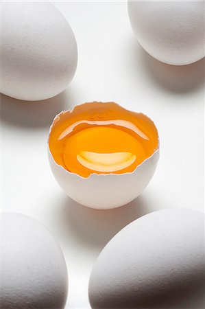 5 eggs on a white surface, one cracked Fotografie stock - Premium Royalty-Free, Codice: 659-07958220