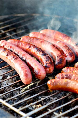 sausage recipe - Chipolata sausages on a smoking barbecue Stock Photo - Premium Royalty-Free, Code: 659-07958279