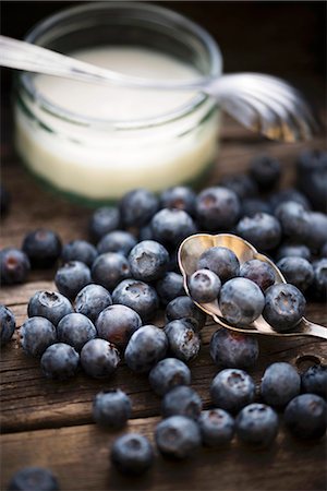 Blueberries in front of a bowl of yogurt Stock Photo - Premium Royalty-Free, Code: 659-07958367