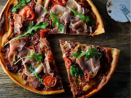 simsearch:659-08147629,k - Pizza with Proscuitto, tomato and rocket, sliced Stock Photo - Premium Royalty-Free, Code: 659-07958371