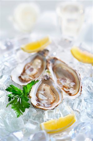 schalentier - Fresh oysters with lemons on ice Photographie de stock - Premium Libres de Droits, Code: 659-07958650