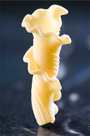 pasta type - A piece of fresh Gigli Toscani pasta standing on a dark marble surface Stock Photo - Premium Royalty-Free, Code: 659-07958756