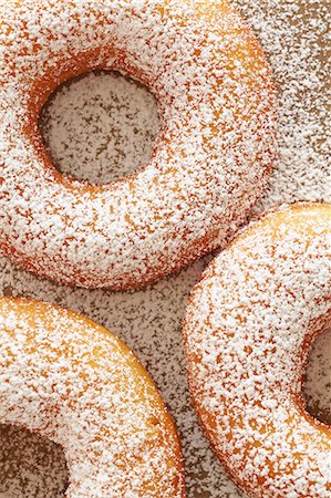 studio shot - Home-made doughnuts dusted with icing sugar (seen from above) Stock Photo - Premium Royalty-Free, Code: 659-07958889
