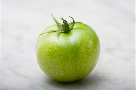 A green tomato on a marble platter Stock Photo - Premium Royalty-Free, Code: 659-07958893