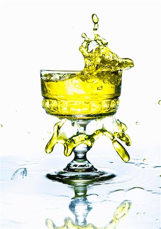 simsearch:659-07599136,k - A yellow drink splashing from a glass Stock Photo - Premium Royalty-Free, Code: 659-07958902