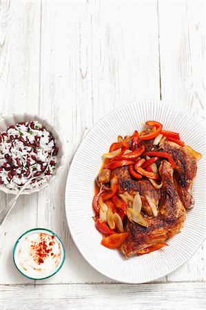 simsearch:659-07959159,k - Roast chicken legs with peppers and onions served with a side of rice Photographie de stock - Premium Libres de Droits, Code: 659-07959160