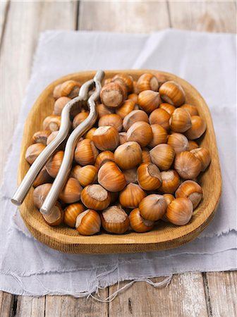filbert - Hazelnuts in a wooden bowl with a nutcracker Stock Photo - Premium Royalty-Free, Code: 659-07959611