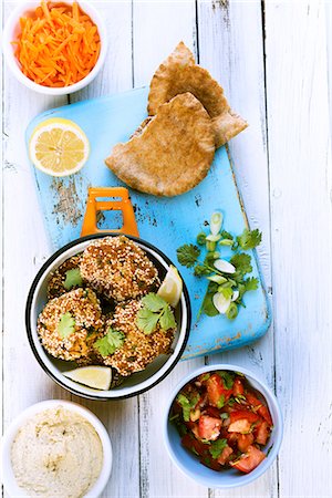 Falafel with hummus, tomato salad, unleavened bread and grated carrots Foto de stock - Sin royalties Premium, Código: 659-07959636