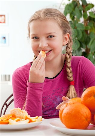 simsearch:659-03536938,k - A girl eating an orange Fotografie stock - Premium Royalty-Free, Codice: 659-07959692