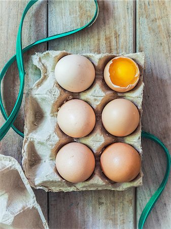 studio shot - Six fresh organic eggs in an egg box, one cracked open Photographie de stock - Premium Libres de Droits, Code: 659-07959786