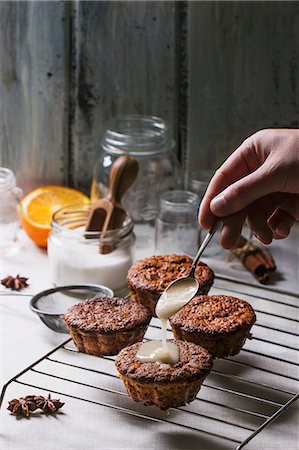 Mini orange cakes being drizzled with glaze Stock Photo - Premium Royalty-Free, Code: 659-07959806