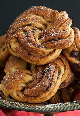 danish - Chocolate and cinnamon buns with icing sugar on a pewter stand Foto de stock - Sin royalties Premium, Código: 659-07959825