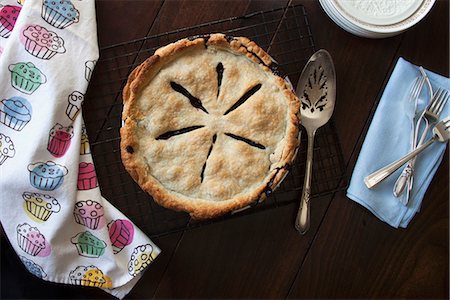 A freshly baked blueberry pie on a wire rack Stock Photo - Premium Royalty-Free, Code: 659-07959907