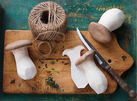 Fresh king trumpet mushroom on a chopping board with a knife and kitchen twine Stock Photo - Premium Royalty-Free, Code: 659-07959938