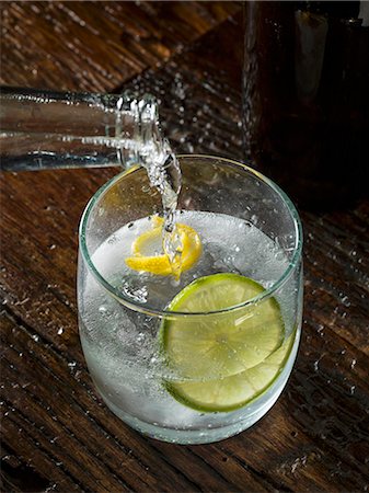 Tonic water being poured into a glass of gin Stock Photo - Premium Royalty-Free, Code: 659-08147042