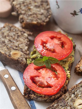 simsearch:659-07597932,k - Flourless bread with sunflower, flax and chia seeds, oats, psyllium seed husks and hazelnuts, served with pesto and fresh tomatoes Stockbilder - Premium RF Lizenzfrei, Bildnummer: 659-08147235