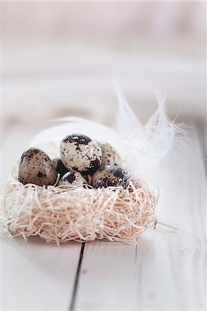 Quail's eggs in a next of hay with a feather Stock Photo - Premium Royalty-Free, Code: 659-08147459