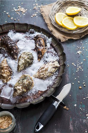 raw oyster - Fresh oysters on ice with an oyster knife and lemon slices Stock Photo - Premium Royalty-Free, Code: 659-08147528