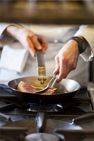 simsearch:400-08254392,k - A chef preparing a steak in a commercial kitchen Foto de stock - Sin royalties Premium, Código: 659-08147604