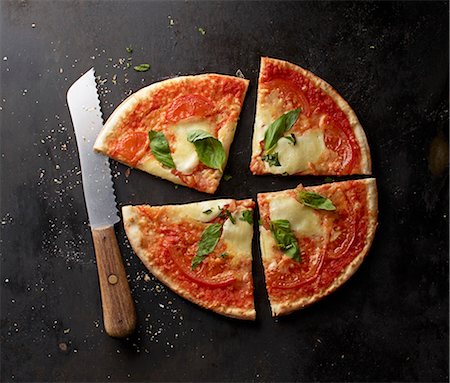 simsearch:659-09124297,k - A tomato, mozzarella and basil pizza, sliced Foto de stock - Sin royalties Premium, Código: 659-08147618