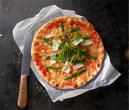 simsearch:659-06903574,k - Pizza Margherita with asparagus, rocket and grated Parmesan on a piece of paper with a knife Foto de stock - Sin royalties Premium, Código: 659-08147628