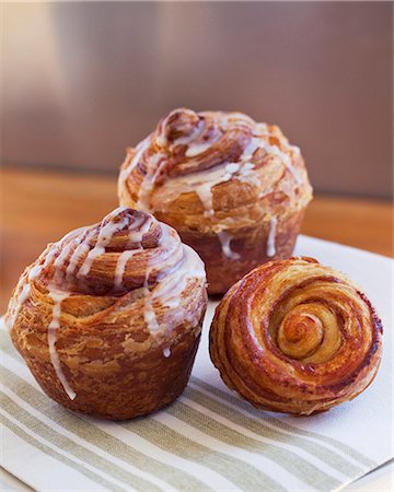 simsearch:659-07028250,k - Three cinnamon buns with icing sugar on a napkin Foto de stock - Sin royalties Premium, Código: 659-08147958