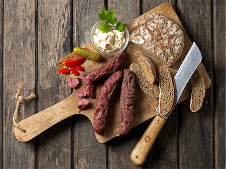 simsearch:659-07598695,k - Kaminwurzen (South Tyrolean smoked sausages) on a bread with horseradish, Vinschgau bread, cornichons and a knife Photographie de stock - Premium Libres de Droits, Code: 659-08147995