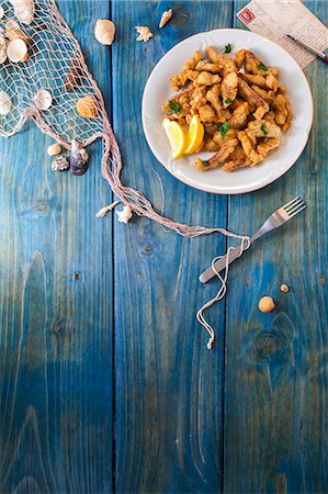 Crispy fish fingers on a blue wooden surface with maritime decorations Photographie de stock - Premium Libres de Droits, Code: 659-08148087