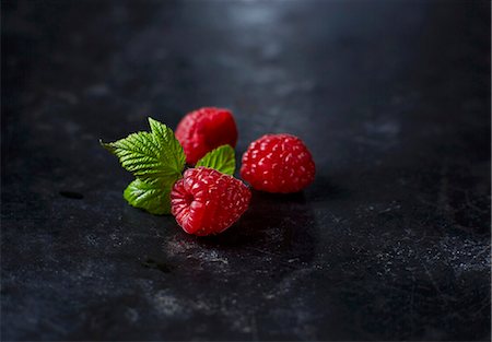 food, dark background - Fresh raspberries with leaves Stock Photo - Premium Royalty-Free, Code: 659-08148167