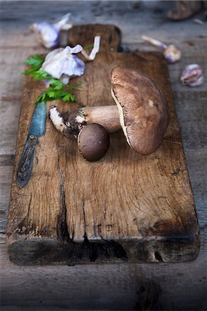 Fresh wild mushrooms and garlic on a rustic wooden chopping board Photographie de stock - Premium Libres de Droits, Code: 659-08148260