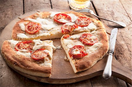 flat bread - A simple tomato and mozzarella pizza Foto de stock - Sin royalties Premium, Código: 659-08418698