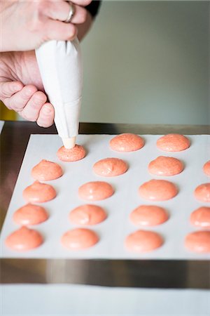 parchment - Pink macaroons being piped onto baking paper Photographie de stock - Premium Libres de Droits, Code: 659-08418767