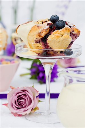 A spiral cake with blueberries and vanilla sauce on a glass stand Foto de stock - Sin royalties Premium, Código: 659-08418834