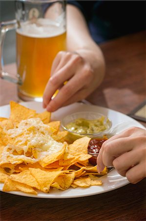 simsearch:400-07993733,k - People eating nachos with cheese and two dips Photographie de stock - Premium Libres de Droits, Code: 659-08418944