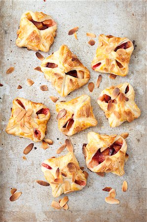 Puff pastry parcels with apples, plums and flaked almonds Stockbilder - Premium RF Lizenzfrei, Bildnummer: 659-08418945