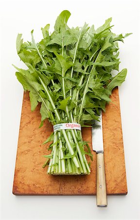 Organic dandelion leaves on a chopping board with a knife Stock Photo - Premium Royalty-Free, Code: 659-08419066