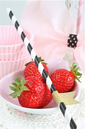 An arrangement of fresh strawberries, a straw and cake cases Stock Photo - Premium Royalty-Free, Code: 659-08419218