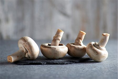 simsearch:659-06495272,k - Four fresh mushrooms on a grey surface Stock Photo - Premium Royalty-Free, Code: 659-08419266