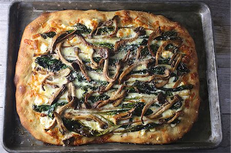 Pan pizza with mushrooms and spinach on a baking tray Photographie de stock - Premium Libres de Droits, Code: 659-08419277