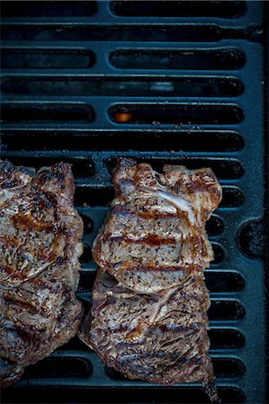 steak on grill - Grilled rib-eye steaks on a barbecue Foto de stock - Sin royalties Premium, Código: 659-08419318