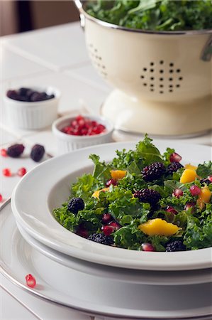 Kale salad with mulberries, pomegranate seeds and mango dressing Foto de stock - Sin royalties Premium, Código: 659-08419325