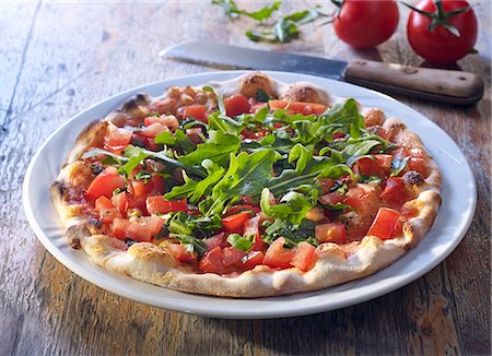 Pizza bread with fresh tomatoes and rocket Photographie de stock - Premium Libres de Droits, Code: 659-08419391