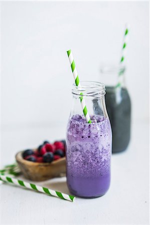 simsearch:659-08905316,k - A blueberry smoothie in a bottle with a straw Photographie de stock - Premium Libres de Droits, Code: 659-08419682