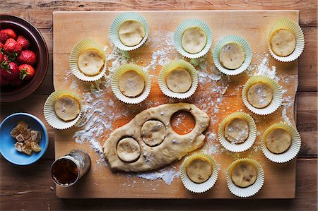 simsearch:659-06184304,k - Pastry being cut out to make ginger and strawberry biscuits Stock Photo - Premium Royalty-Free, Code: 659-08419683