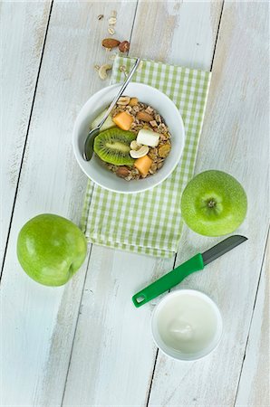 simsearch:659-08896356,k - A healthy breakfast: muesli with fresh fruits, nuts and milk, kiwi, apple and melon on a wooden table Photographie de stock - Premium Libres de Droits, Code: 659-08419701