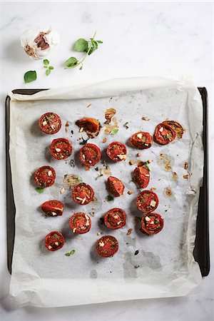 simsearch:659-06154031,k - Oven-roasted zebra tomatoes on a baking tray lined with baking paper (seen from above) Photographie de stock - Premium Libres de Droits, Code: 659-08419811