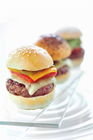 small - Three mini hamburgers in a row on a glass platter Stock Photo - Premium Royalty-Free, Code: 659-08419890