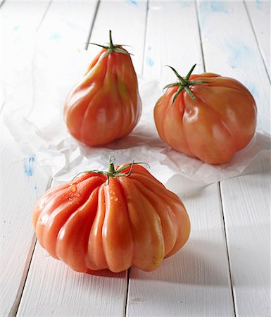 simsearch:659-06902877,k - Three beefsteak tomatoes on a white wooden surface Foto de stock - Sin royalties Premium, Código: 659-08420015